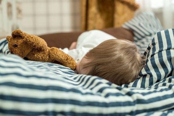 Close up face of Kid yawning and holding teddy bear, Sleepy child yawning and looking at cameta, Head shot tired child get a cold during weather change