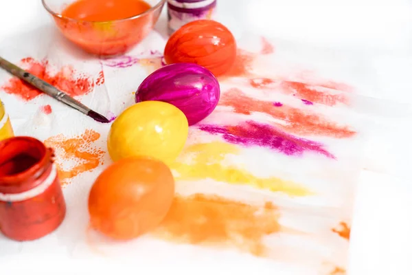 Pastel Easter Eggs o processo de colorir ovos para a Páscoa. pintura multicolorida sobre papel. Os ovos brilhantes são amarelo, laranja, vermelho e roxo . — Fotografia de Stock