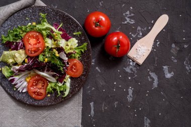 Mor lahanalı taze sebze salatası, beyaz lahana, marul, siyah arka planda koyu kil kasede havuç. Üst görünüm