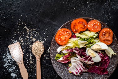 Siyah arka plandaki sebzeler. Organik gıdalar ve taze sebzeler. Salatalık, lahana, biber, salata, havuç, brokoli, marul ve domates masada.