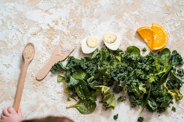 Salad with spinach leaves and eggs in bowl on wooden table