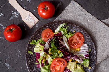 Mor lahanalı taze sebze salatası, beyaz lahana, marul, siyah arka planda koyu kil kasede havuç. Üst görünüm