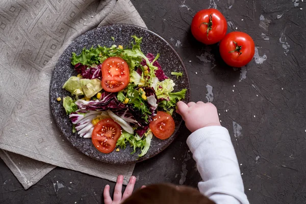 Ensalada de verduras frescas con col morada, col blanca, lechuga, zanahoria en un tazón de barro oscuro sobre fondo negro. Vista superior — Foto de Stock