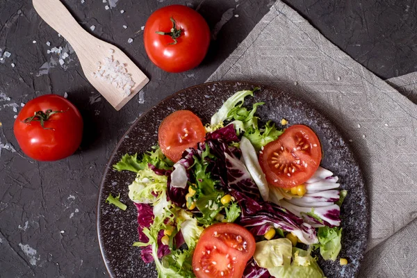 Mor lahanalı taze sebze salatası, beyaz lahana, marul, siyah arka planda koyu kil kasede havuç. Üst görünüm