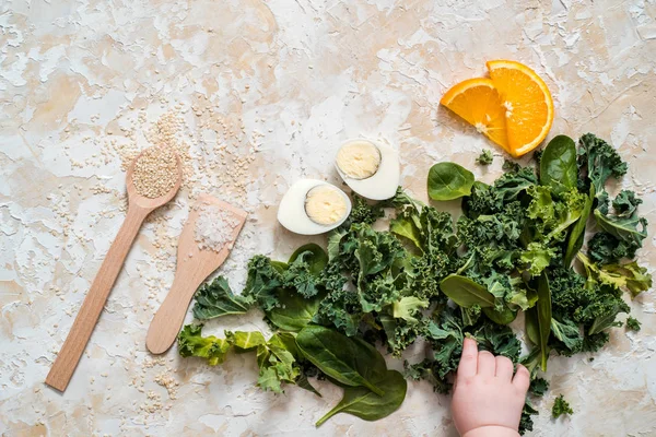 Salad with spinach leaves and eggs in bowl on wooden table