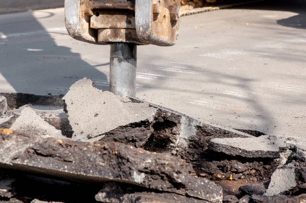 makine sondajları asfalt. Yolun her yerinde büyük toprak parçaları ve çukurlar. matkap ile çalışma ekipmanları yüksek sesle çalışır