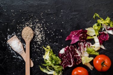 Taze olgun ev yapımı sebze salatası. Sağlıklı yemek pişirmek için vejetaryen madde ve zeytinyağı. Dilimlenmiş beyaz lahana, kırmızı biber, domates, arugula, siyah susam. Organik sağlıklı gıda konsepti.