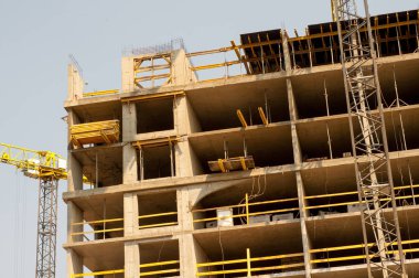 Yüksek katlı bir vinç ile bina inşaatı. Bina inşaat kalıp kullanarak. İnşaat Vinç ve mavi gökyüzü karşı bina.