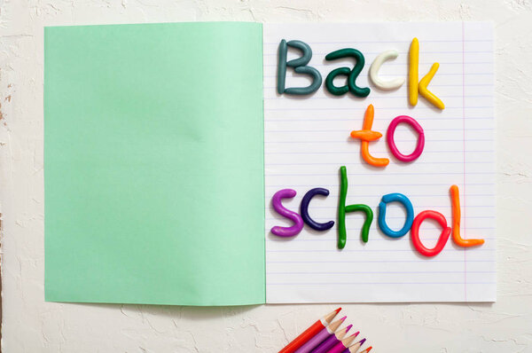 School supplies and inscription back to school on color background