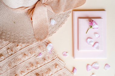 Onun yaz tatili hakkında düşünme soluk pembe yazlık elbise, hasır şapka ve güneş gözlüğü, zarif çekici kadın. Chin, pastel mavi arka plan üzerinde izole üzerinde el ile kadın yan görünüm.