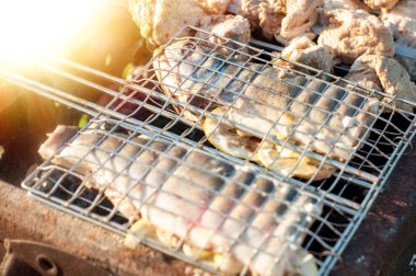 Kömürü taşımak ve barbekünün ateşini yakmak için cımbız tutan bir adamın elleri. Barbekü için karbon. Küçük Avrupa köyünde barbekü.