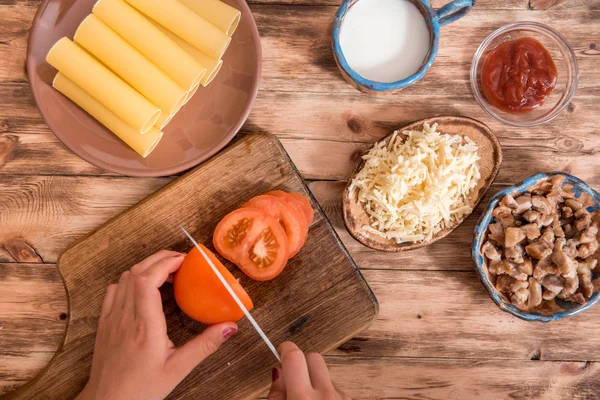 Concepto de comida italiana. Ingredientes para cocinar pasta. Pastas secas de canelones, tomates cherry, albahaca fresca, ajo sobre fondo negro . — Foto de Stock