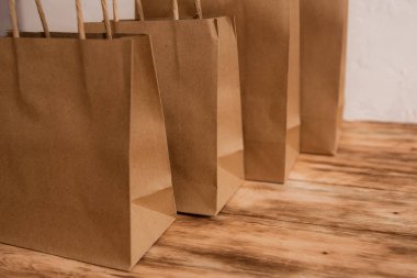 Mock-up kahverengi craft kağıt paket kulplu, boş alışveriş çantası için logo veya tasarım, ahşap tahta arka plan, gıda dağıtım, satış, tüketim ve reklam kavramı bulunduðu.