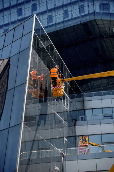 A Team Of Climbing Workers Clean the Windows on Skyscraper