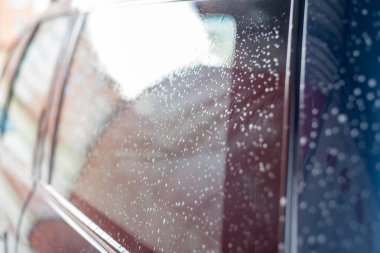 Oto yıkama, bol su ve köpük. Arabanın camlarını damla damla.