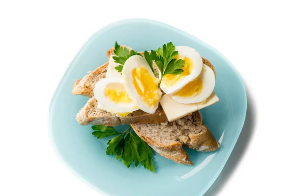 Жареное яйцо на завтрак. Жареное яйцо с хлебом и петрушкой на белой тарелке на черном, вид сверху, пространство для копирования . — стоковое фото