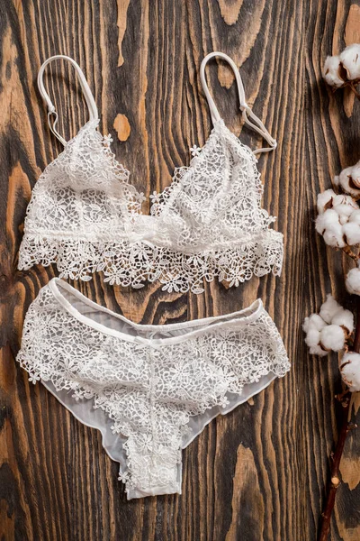 Pamuk çizgili külot ve beyaz sütyen. Beton arka planda kadın iç çamaşırı. Moda kadın iç çamaşırı üst görünümü. Doğal yumuşak kumaş