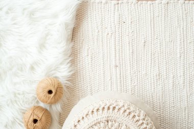 İplikler, örülmüş yuvarlak peçete. Çiçek gibi beyaz peçete. Kürk beyazı arka planda ve örgü örülmüş hafif arka planda. Hasır bir kutuda iplik topları. Rahat ev ve el yapımı konsept.