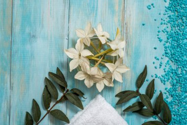 Çiçekli spa ve sağlık seti ve eski ahşap arka planda beyaz havlu. Mavi spa doğa seti. çoklu uzay. Tatil konsepti. Düz yat. en üstteki görünüm.