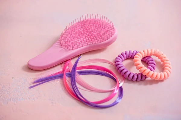 Light pink comb, purple decorative hair for girls hairstyles. Decoration for teenage girls. Silicone rubber band. copy space. flat lay. top view.