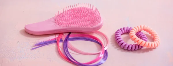 long banner Light pink comb, purple decorative hair for girls hairstyles. Decoration for teenage girls. Silicone rubber band. copy space. flat lay. top view.