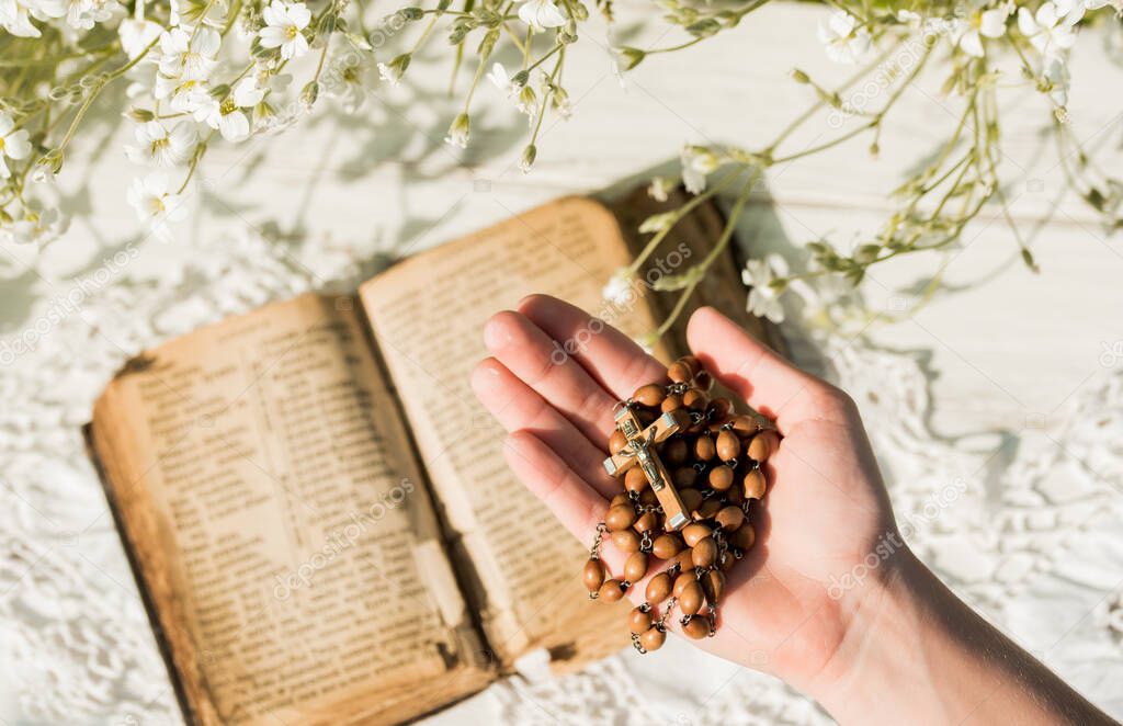 Manos dobladas en oración sobre la antigua Santa Biblia. Fondo de
