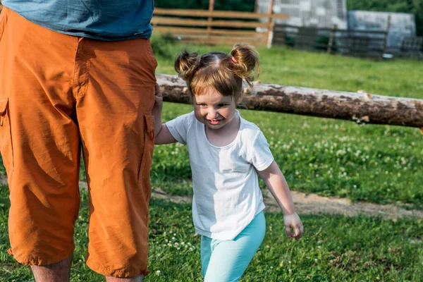 父と娘は公園で泡を作っています 陽気で美しい赤ちゃんの女の子が走り 泡をキャッチします 幸せな子供時代 晴れた夏の夜日没 — ストック写真