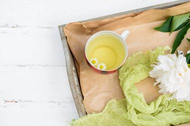 Tahta beyaz arka planda sıcak çay, doğal bitki çayının hazırlanması için gerekli malzemeler. Melissa ve nane, papatya ve frenk üzümü, ahududu. Köyde sabah.Top wiew.