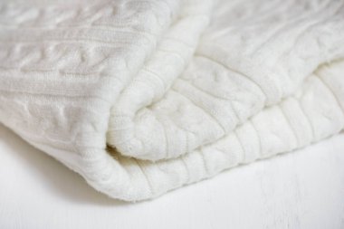 Beyaz örgü kumaş dokusu. Örgü, el yapımı. Sarı sonbahar yaprağı..