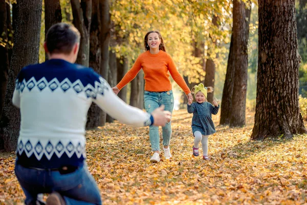 秋の日に葉に実行している若い家族の笑顔 アクティブなゲーム — ストック写真