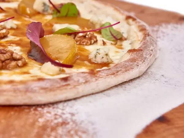 Ahşap üzerine yayılmış buğday unuyla süslenmiş pizza. ruh hali