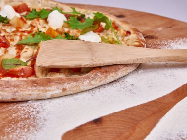 Açılmış buğday unu ve çeviriciyle süslenmiş ahşap pizza. ruh hali