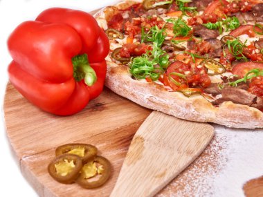 Sıcak Meksika pizzası ahşap üzerine yayılmış buğday unu, jalapeno ve çevirici ile süslenmiş. ruh hali