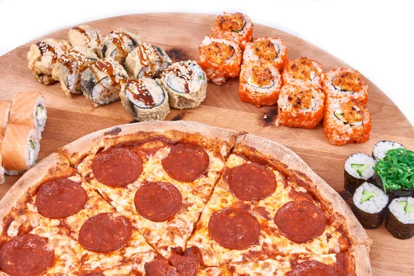 Pepperoni pizza with sushi rolls set on wood isolated