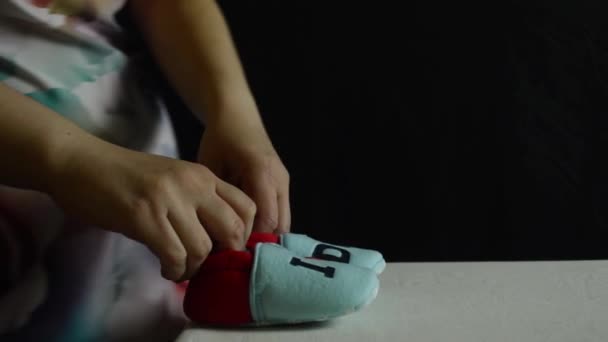 Беременная Женщина Играет Детскими Туфельками Руках — стоковое видео