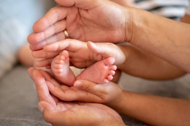 Bebeğin küçük bacakları sarılma babasının ve annesinin elleri