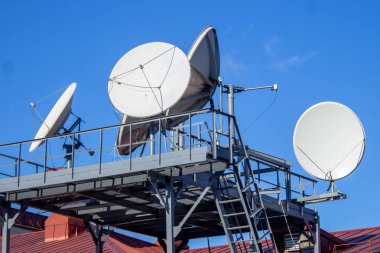Bina, mavi gökyüzü, parabolik anten çatısında çanak antenler