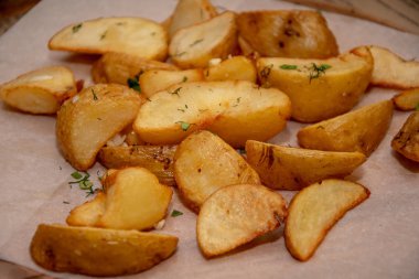 Altın kabuk ile patates kızarmış parçalar kağıt yüzeyinde yalan, dereotu ve otlar serpilir