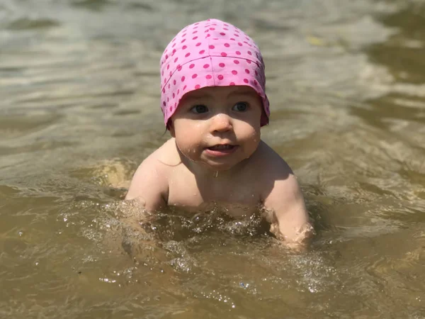 Little girl swimming in the sea, waves on the beach, summer vacation