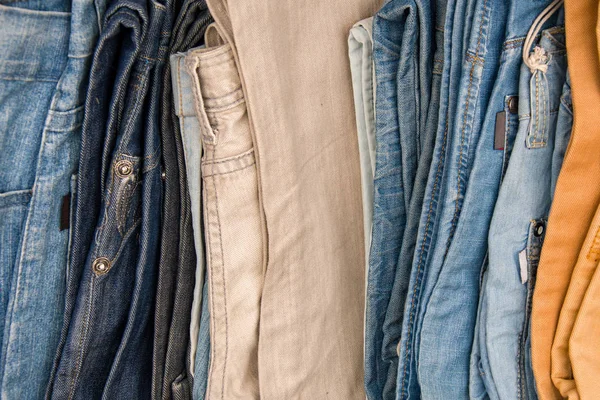 Denim pants folded in a pile on the counter, trade of men\'s trousers