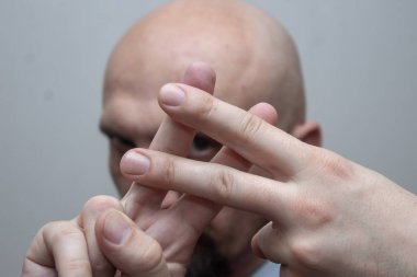 Takım elbiseli kel adam parmaklarını gösterir. Kafes işareti, hashtag, müzik keskin, hapis karşı karşıya, parmaklarda netlik.