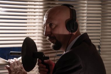 Gizli ajan gizlice perdeler, gözetim ve insanların kontrolü, ortalama planı iterek yön mikrofon dinleme