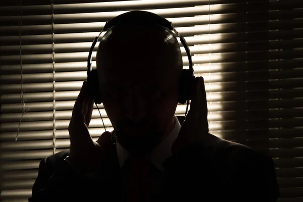 Bald Man Headphones Background Closed Blinds Contour Lighting Listening Music — Stock Photo, Image