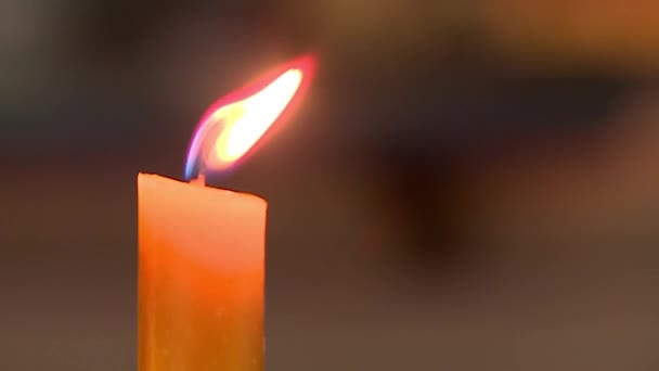 一支蜡烛在教堂里燃烧着黄色的火焰 火焰在摇地 模糊的背景 — 图库视频影像