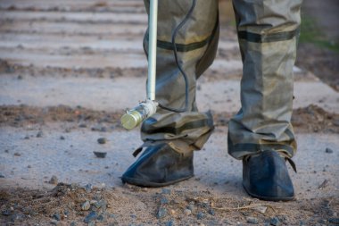 Koruyucu kauçuk takım elbise, askeri dosimetre radyoaktivite ölçümü. Yasak bölgede beton yol.