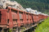 Der mit Steinen und Mineralien beladene Zug steht auf dem Abstellgleis. Bergbau und Eisenbahnfracht.