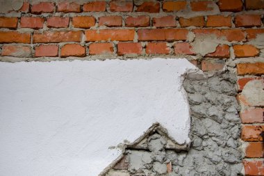 Kırmızı kil tuğla duvar çimento ve alçıyla kaplıdır. Evin inşaatı ile ilgili. Binaların ön cephelerini tamamlamak için inşaat malzemeleri.