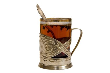 Bardak tutacağında bir bardak çay, beyaz arka planda bir kaşık, izole edilmiş.