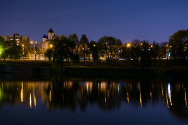Night lighting of the city, cityscape, Orthodox Church near the pond.