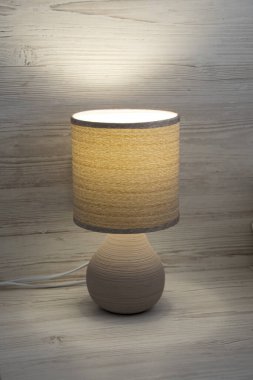 Masa başı lambası yumuşak sarı bir ışık, abajur kumaş desenli.,